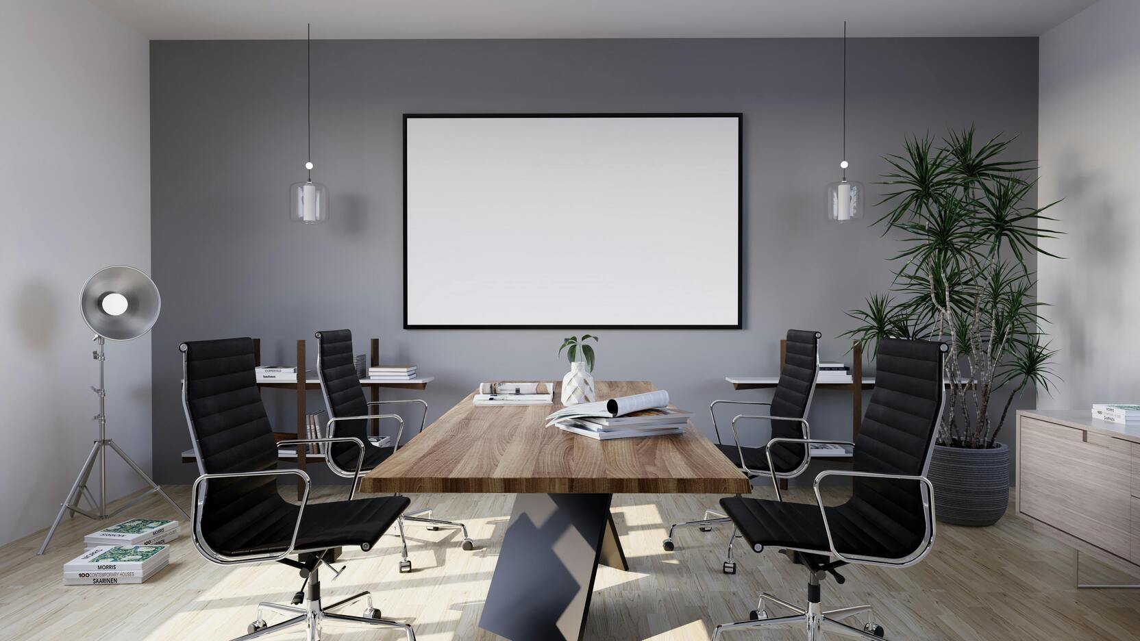 Moderne Konferenzraum mit schwarzem Tisch, Bürostühlen, Pflanzen und leinwandähnlicher Wandfläche.